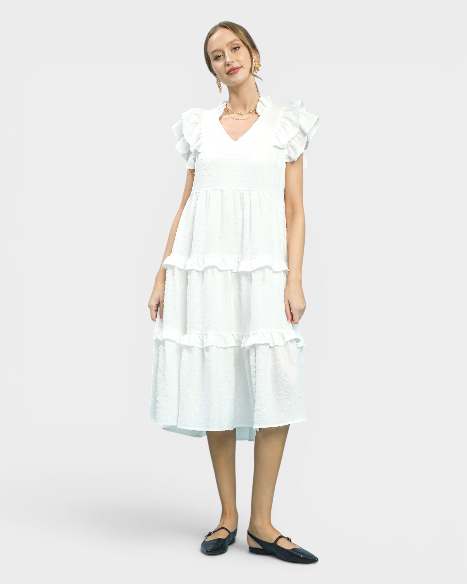 Woman wearing a white dress on a plain background