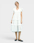 Woman wearing a white dress on a plain background