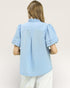 Person wearing a light blue textured shirt on a plain background