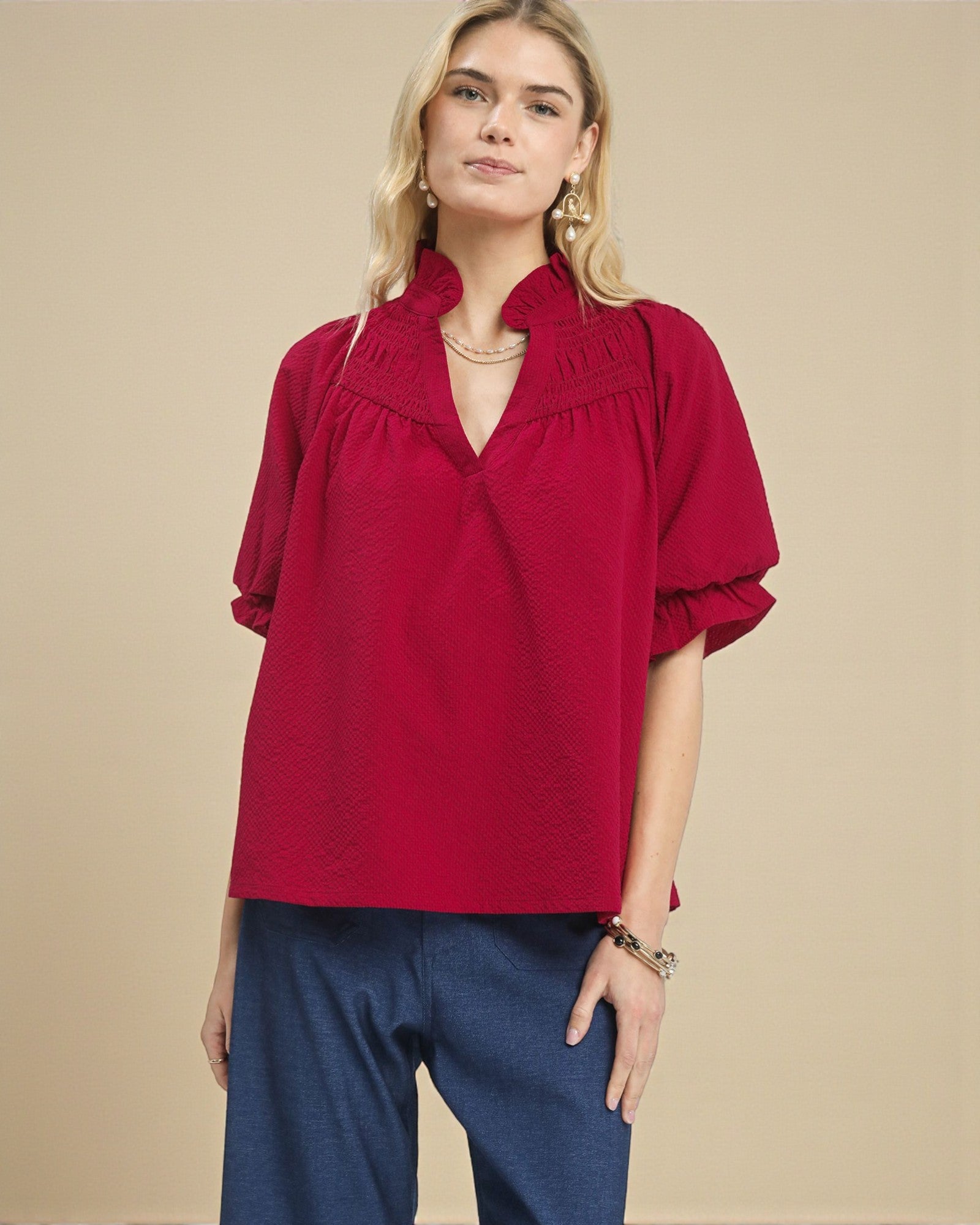 Woman wearing a red blouse with a beige background