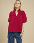 Woman wearing a red blouse with a beige background