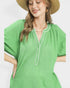 Woman wearing a green dress with a pearl necklace against a white background