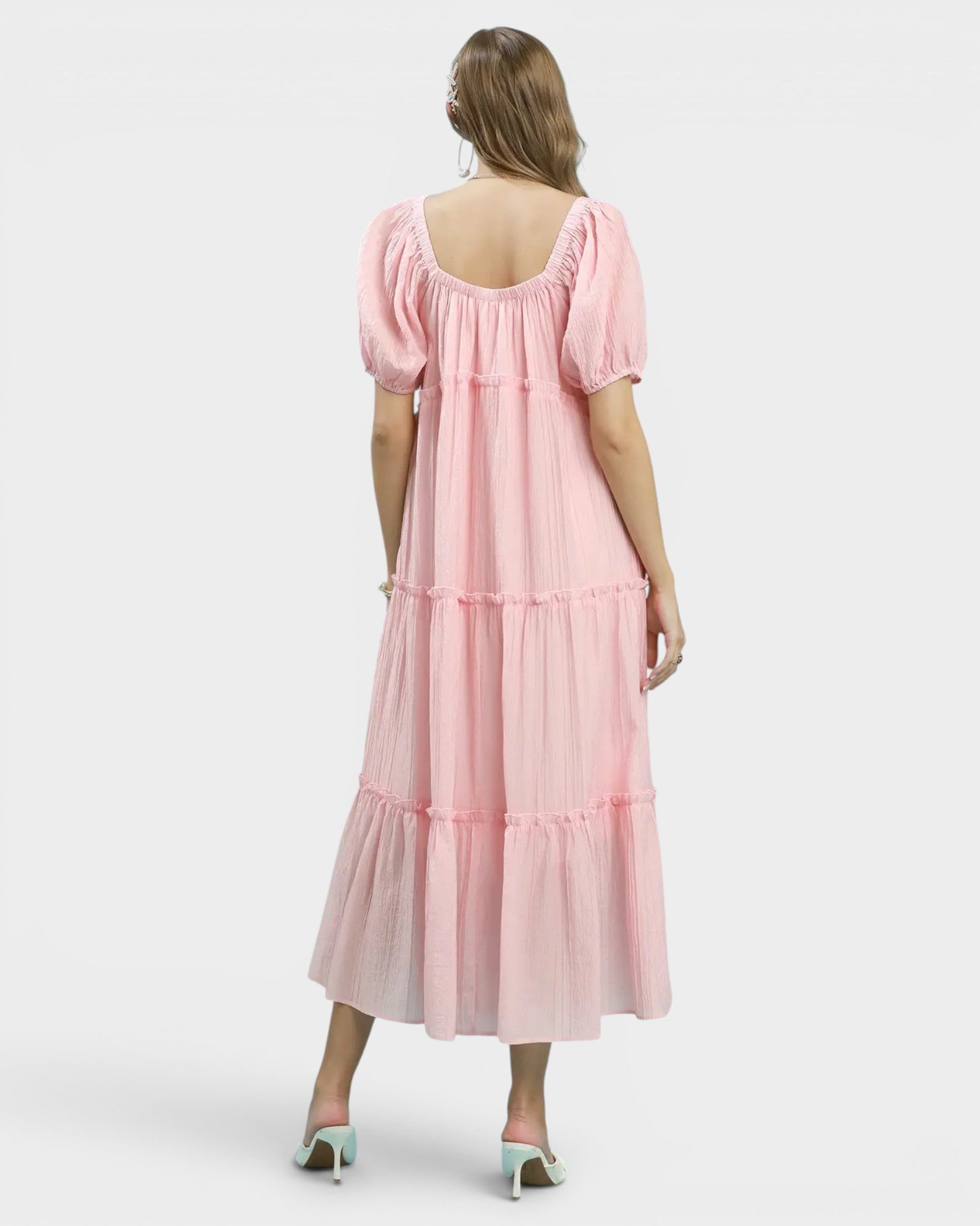 Woman wearing a pink dress with a white background