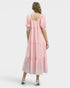 Woman wearing a pink dress with a white background
