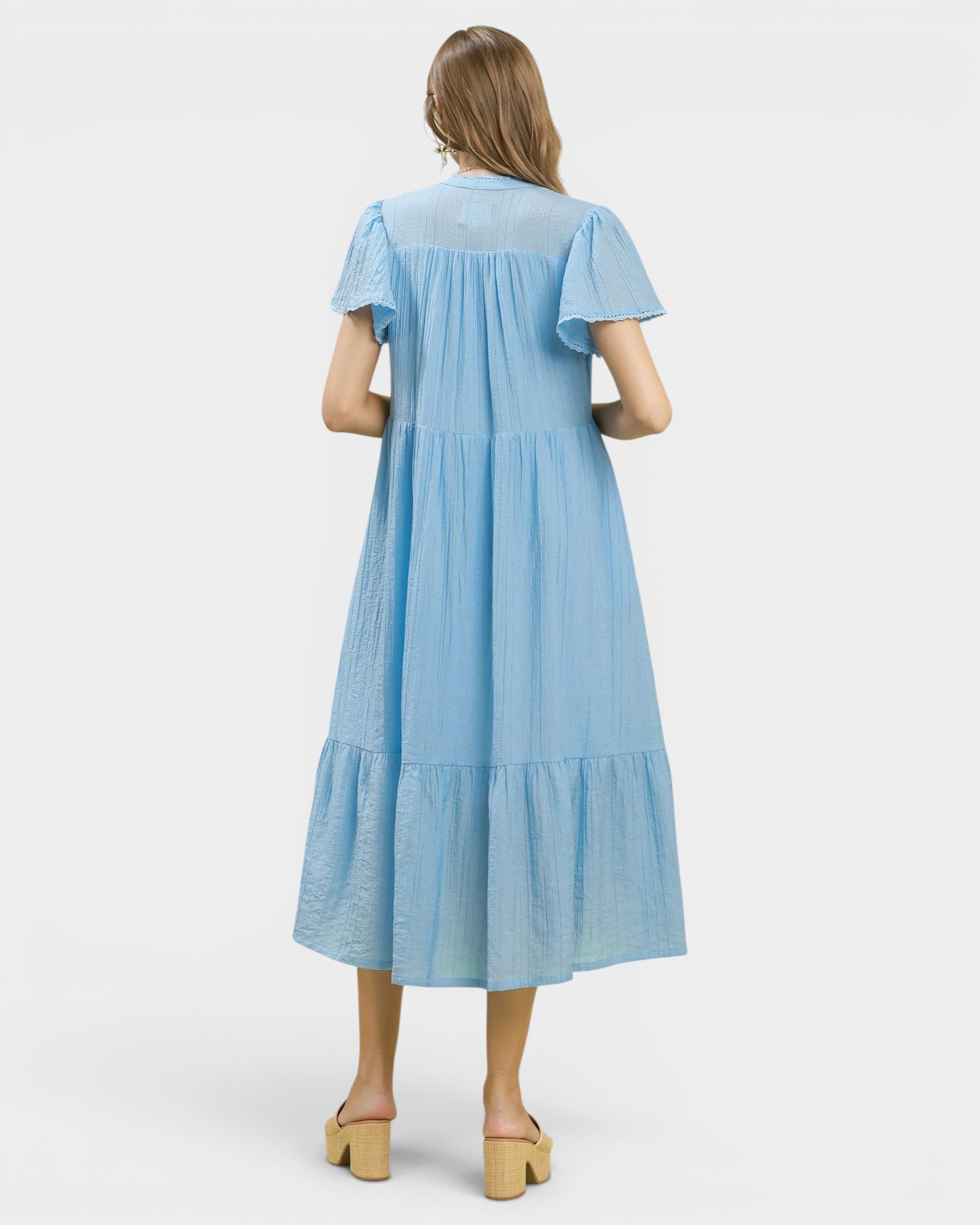 Woman wearing a light blue dress on a white background