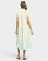 Woman wearing a cream dress on a white background