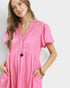 Woman wearing a pink dress with a plain background