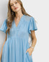 Woman wearing a blue dress against a plain background