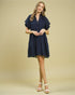 Woman wearing a navy blue dress on a beige background