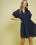 Woman wearing a navy blue dress against a yellow background