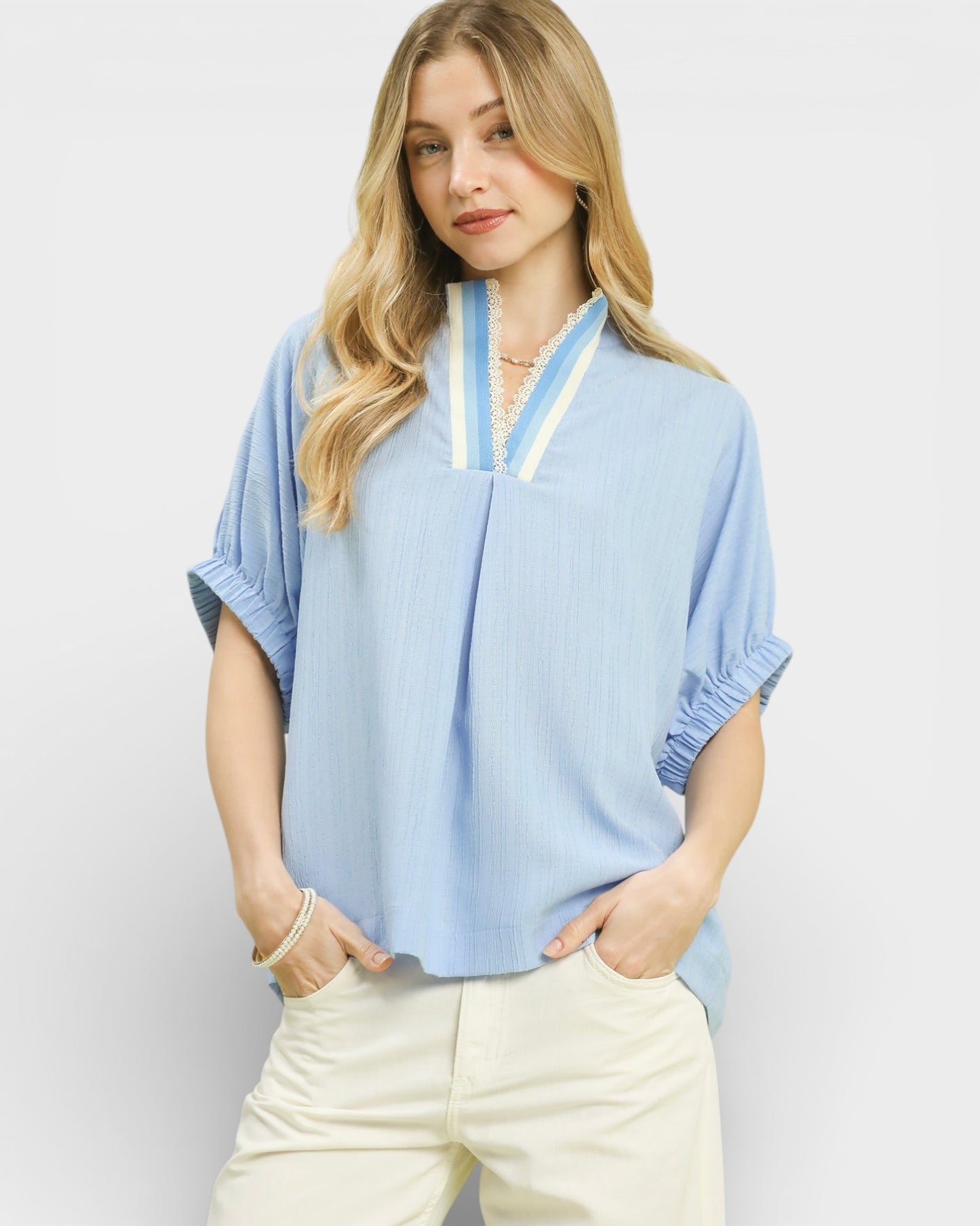 Woman wearing a light blue blouse with a white background