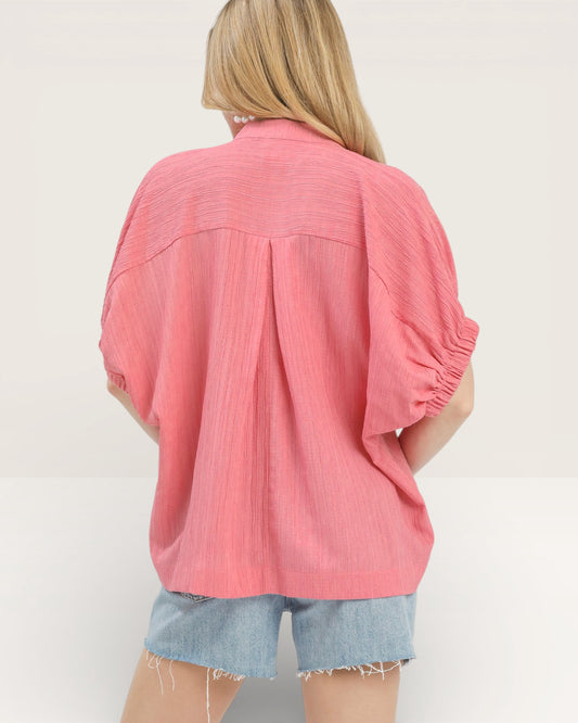 Person wearing a pink blouse with a white background
