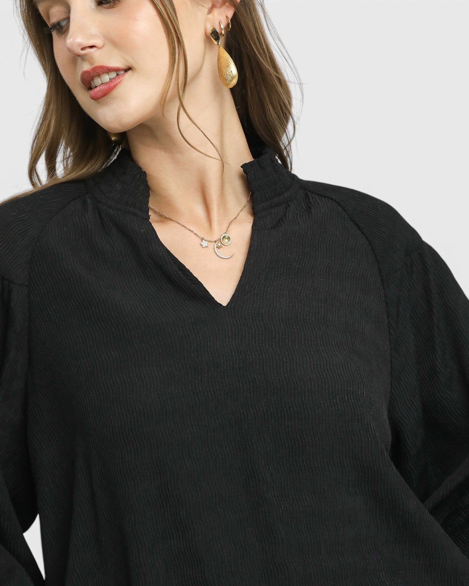 Woman wearing a black top with a plain background