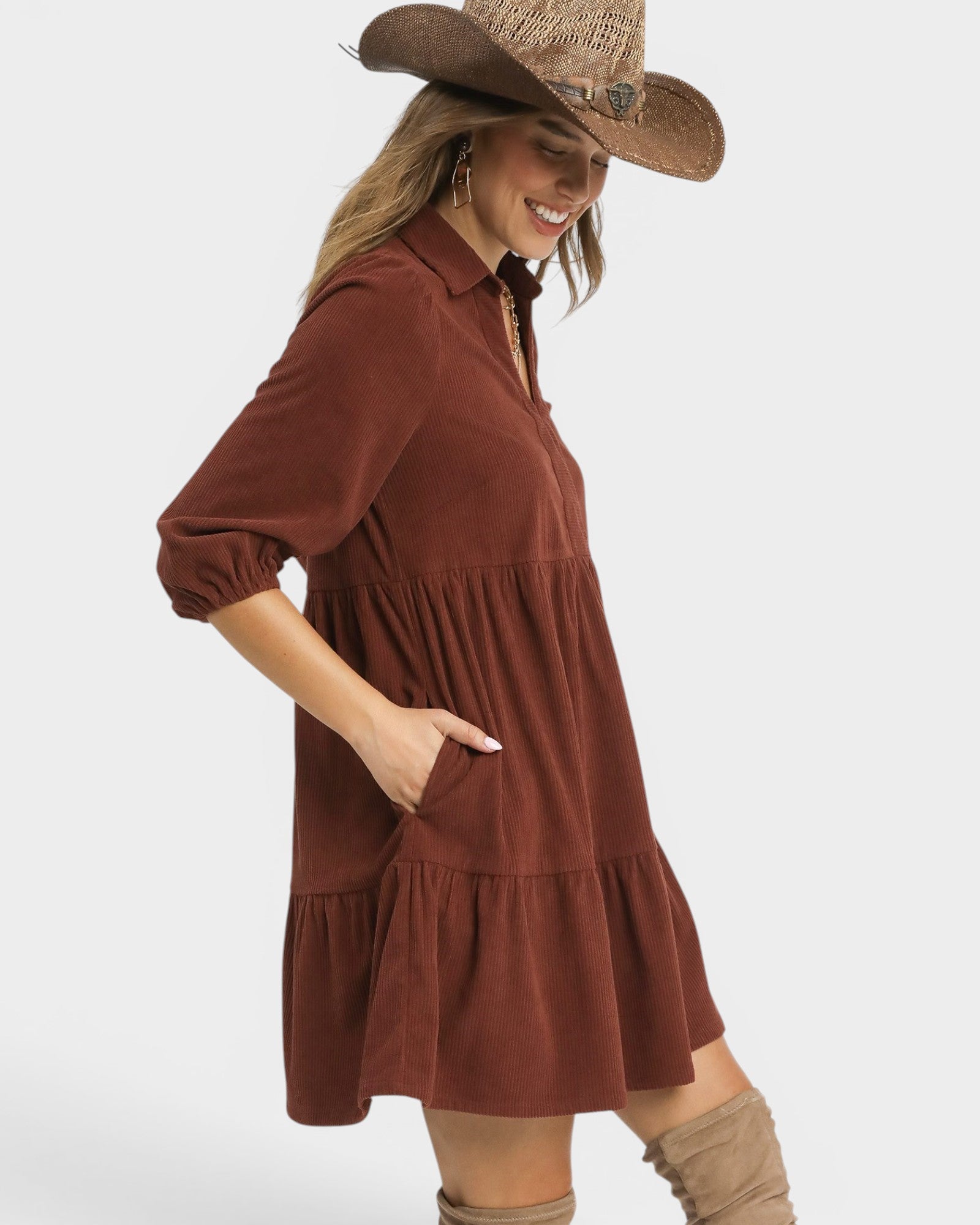 Woman wearing a brown dress and straw hat on a white background