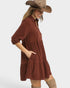 Woman wearing a brown dress and straw hat on a white background