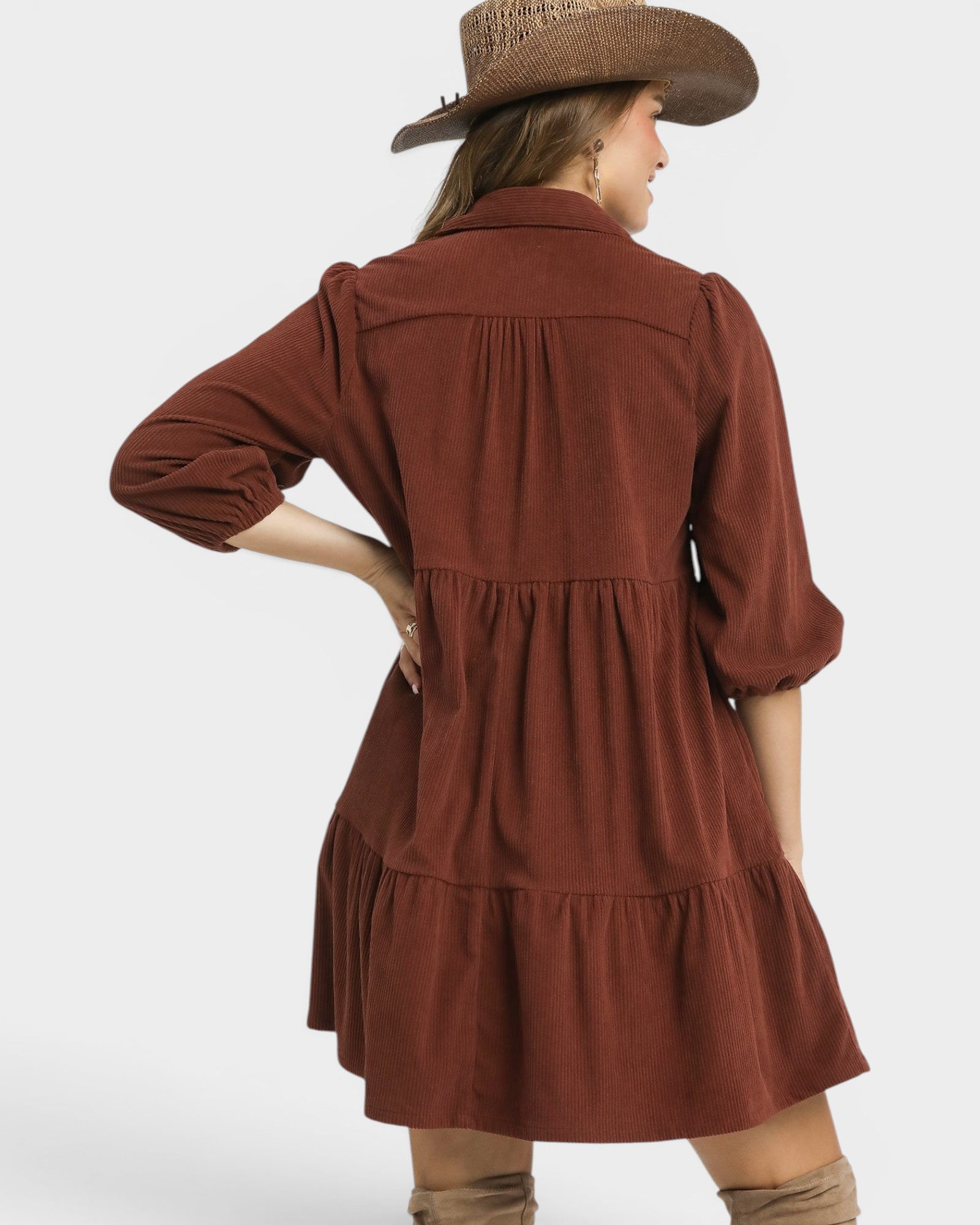 Woman wearing a brown dress with a hat on a white background
