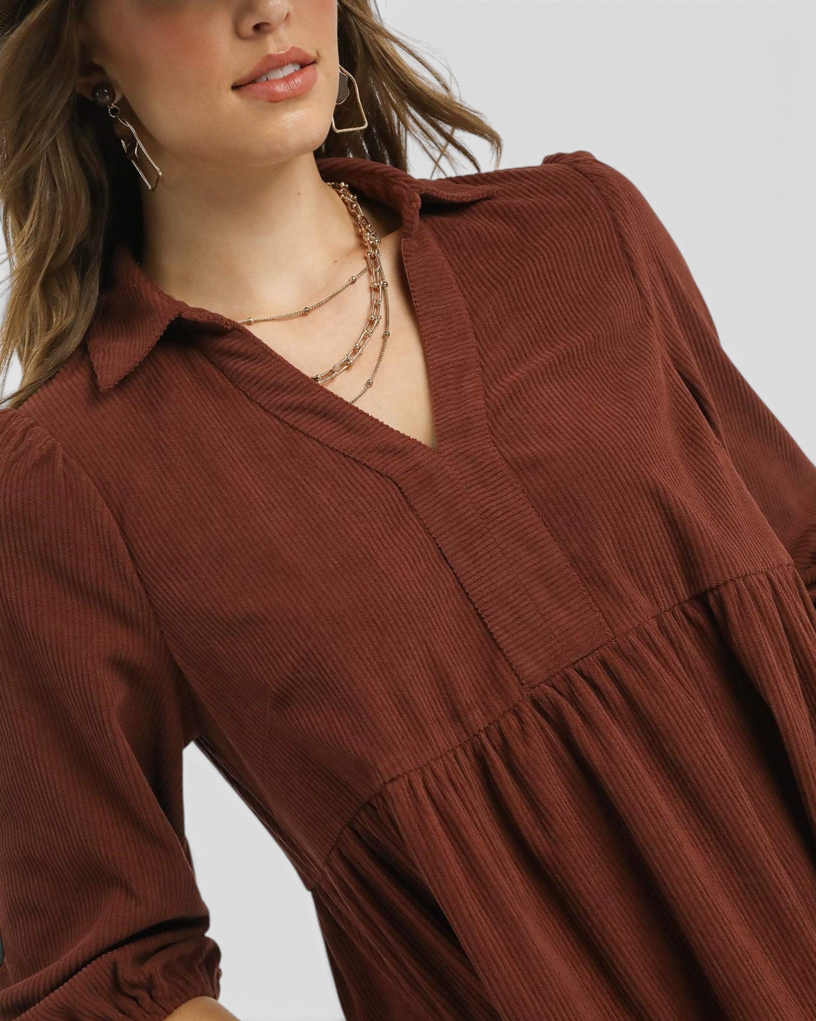 Brown dress worn by a model on a plain background