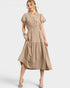 Woman wearing a beige dress with white trim on a white background