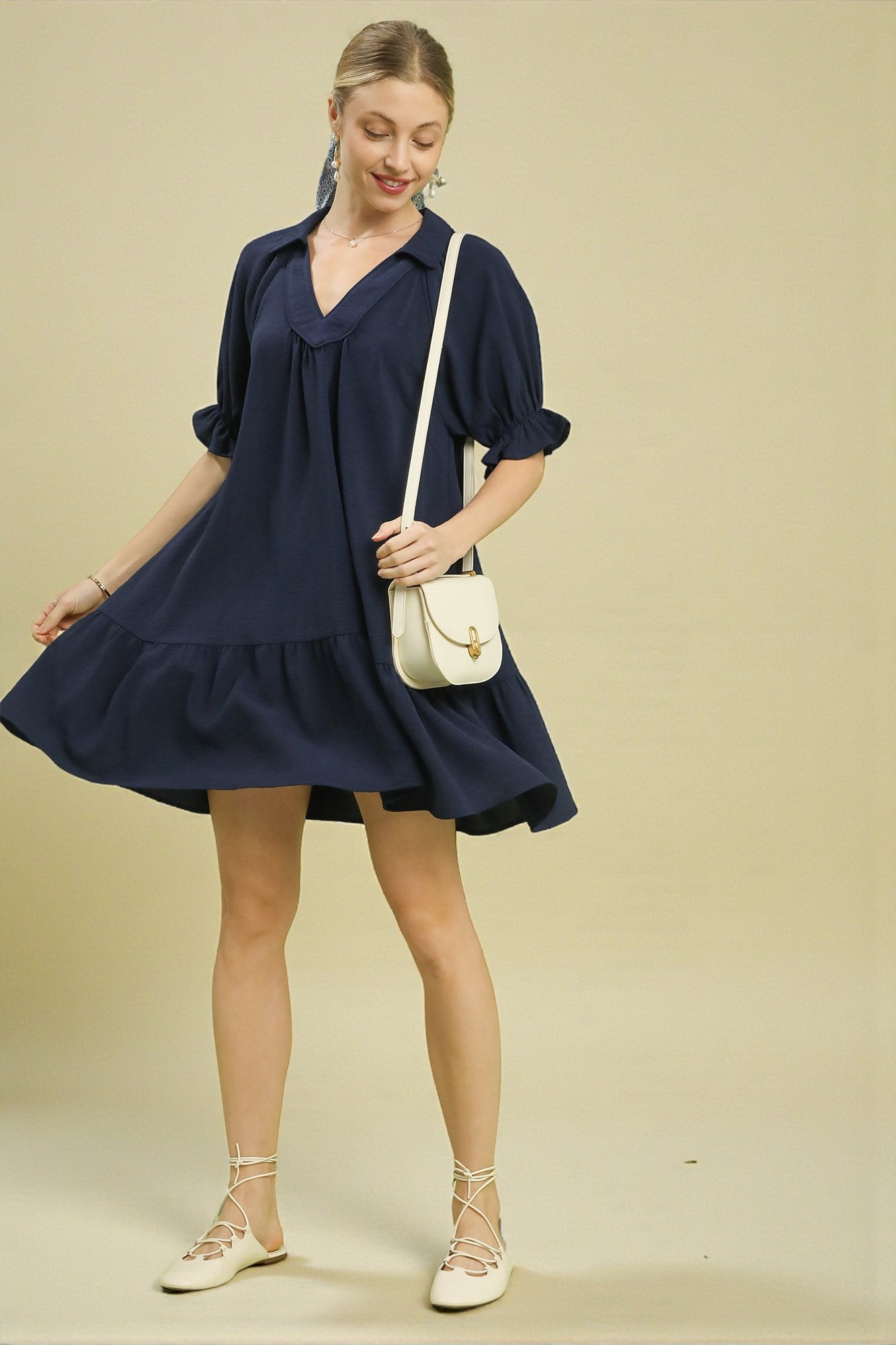 Woman wearing a navy blue dress with a white background