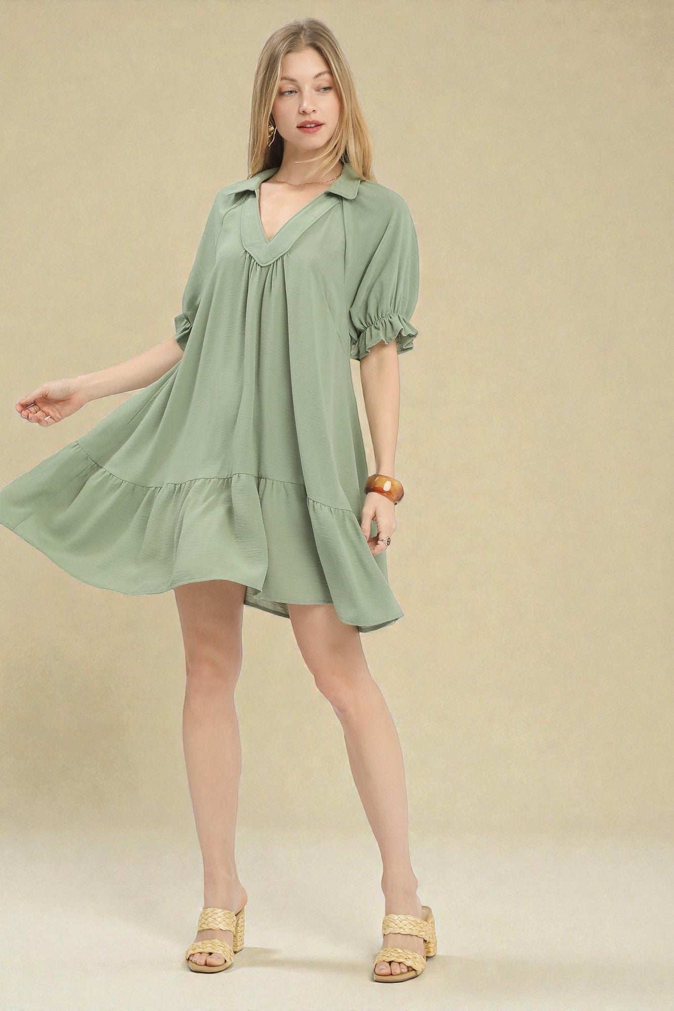 Woman wearing a green dress against a beige background