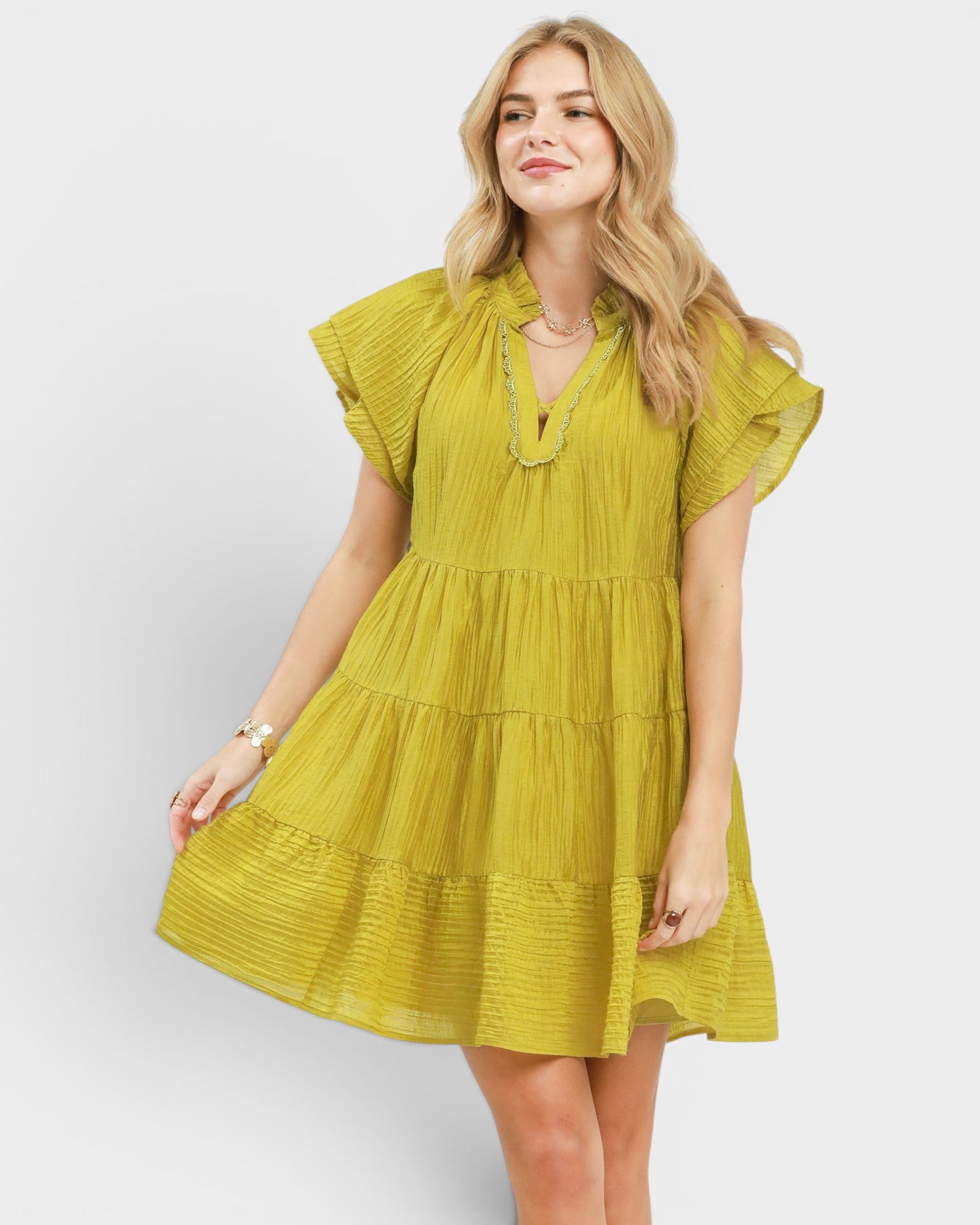 Woman wearing a yellow dress against a white background
