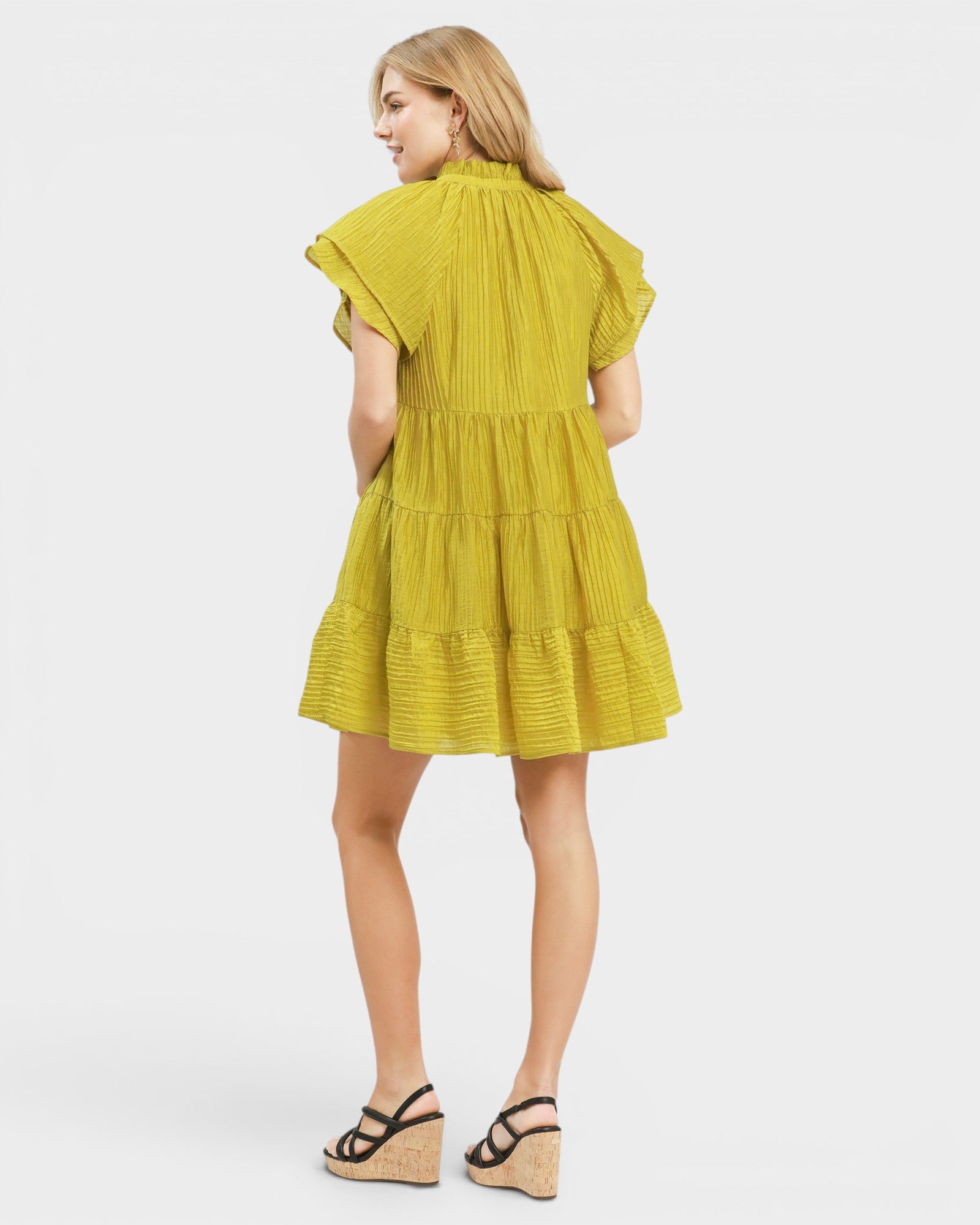 Woman wearing a yellow dress on a white background