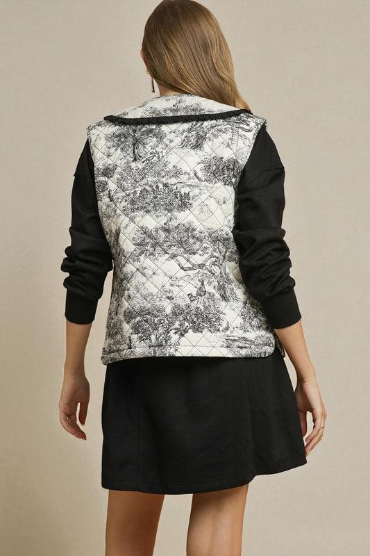 Person wearing a black and white patterned vest over a black outfit on a beige background