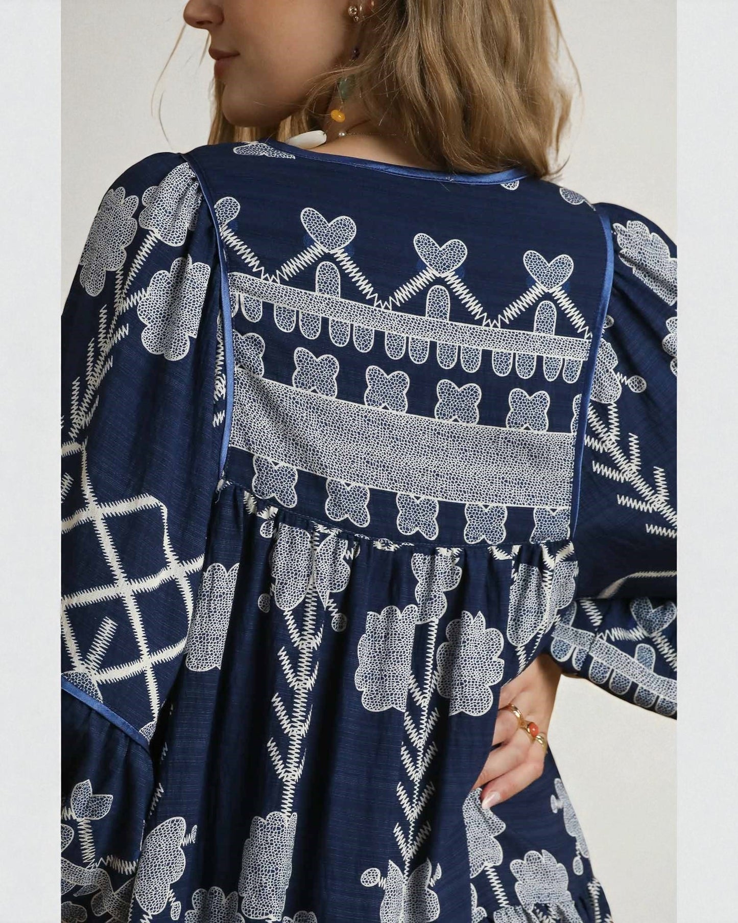 Navy blue dress with white floral patterns worn by a person