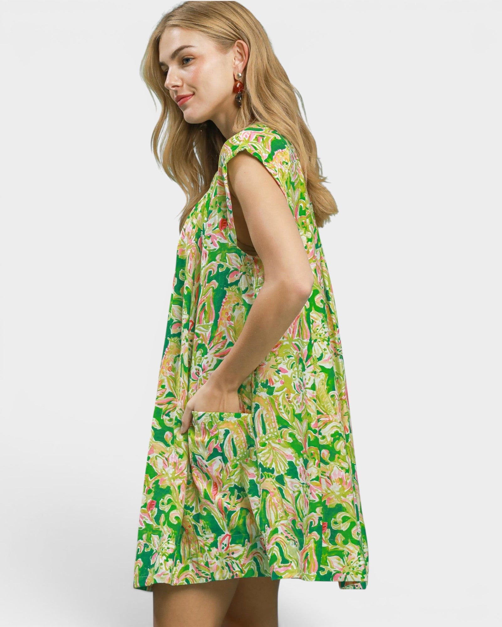 Woman wearing a green floral dress on a white background