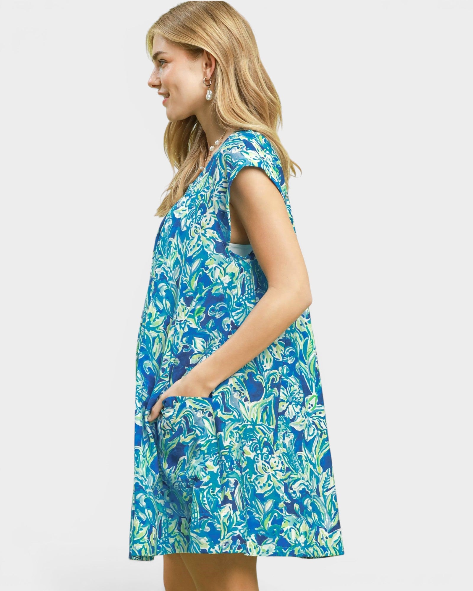 Woman wearing a blue floral dress on a white background