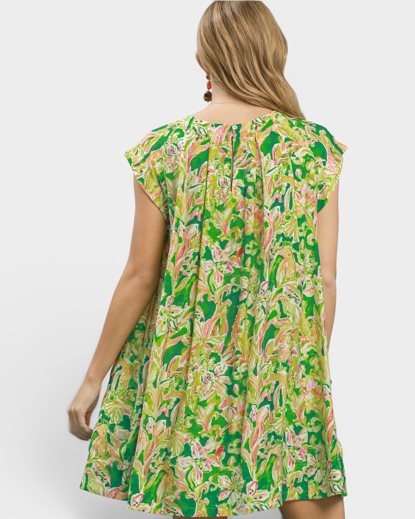 Woman wearing a green floral dress on a white background