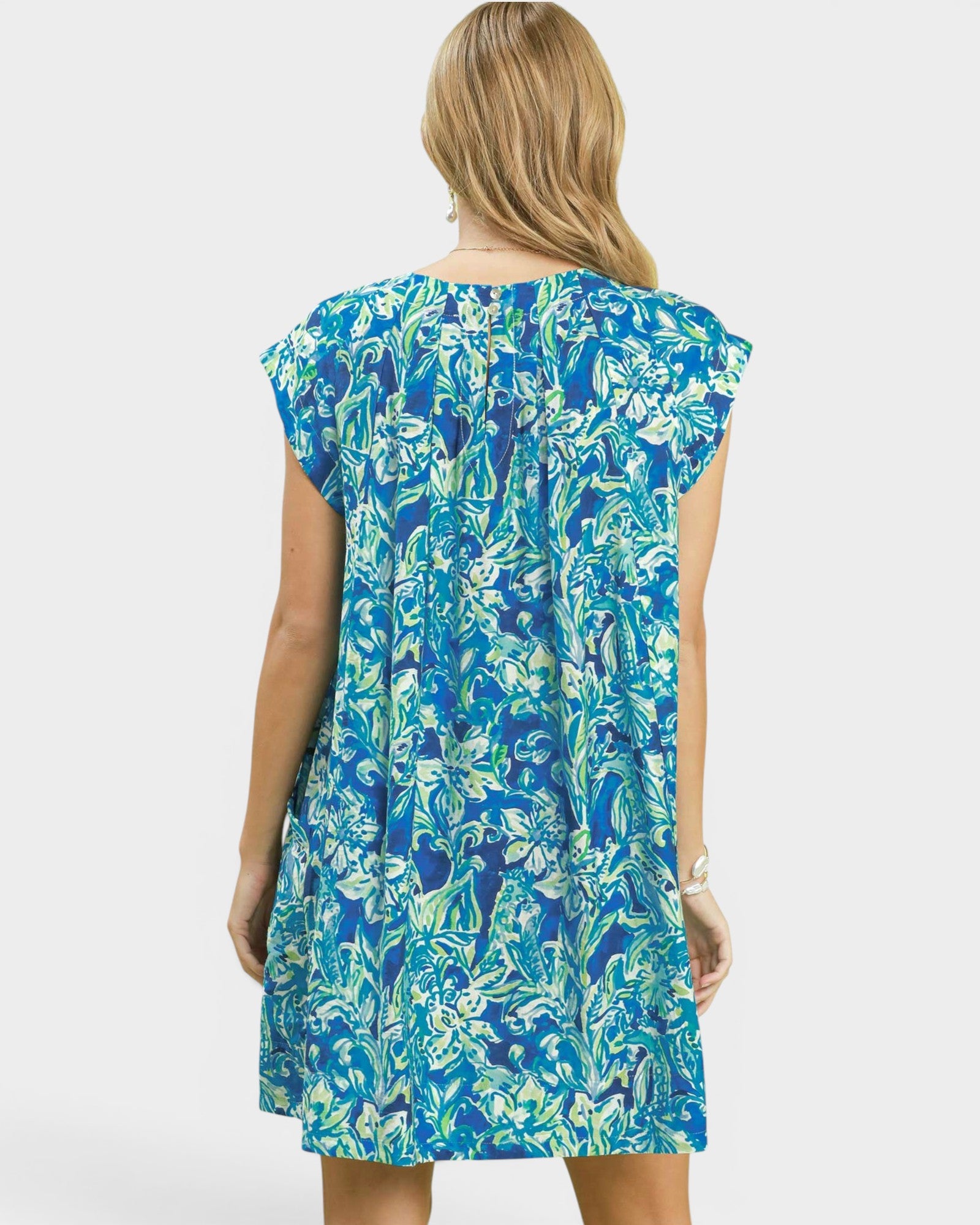 Woman wearing a blue floral dress on a white background