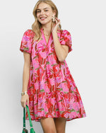 Woman wearing a pink floral dress against a white background