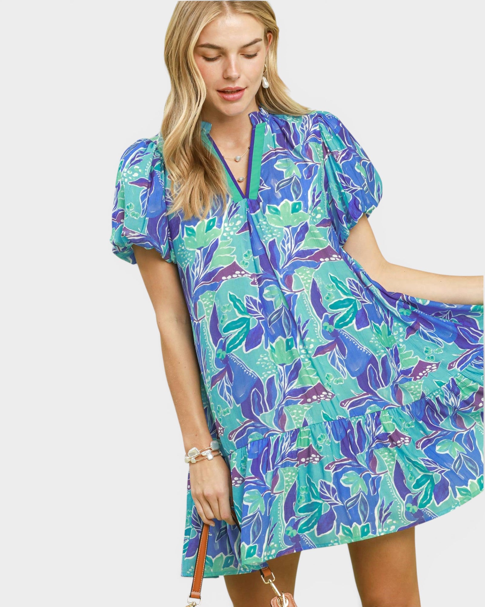 Woman wearing a blue and green floral dress on a white background