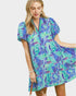 Woman wearing a blue and green floral dress on a white background