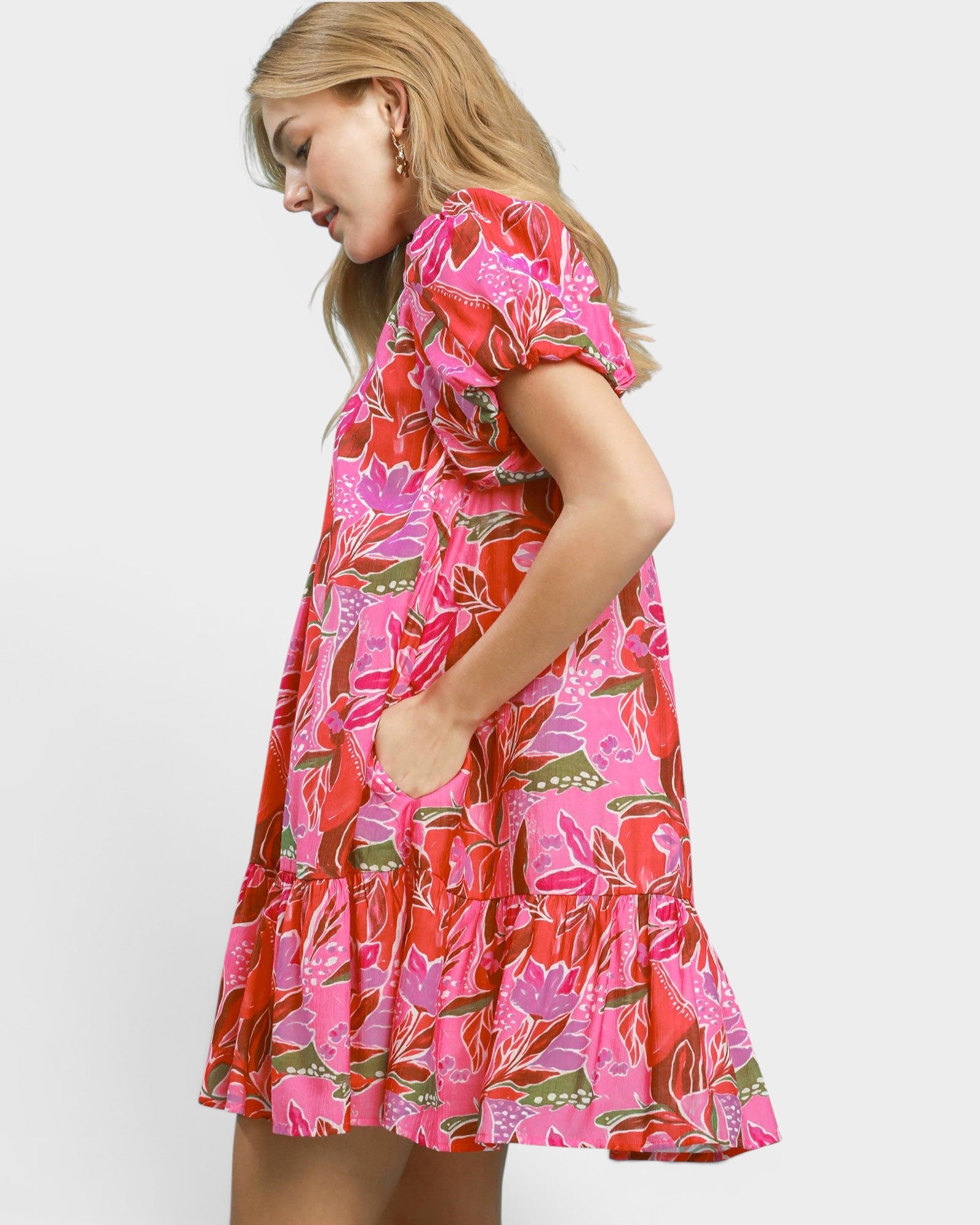 Woman wearing a colorful floral dress on a white background