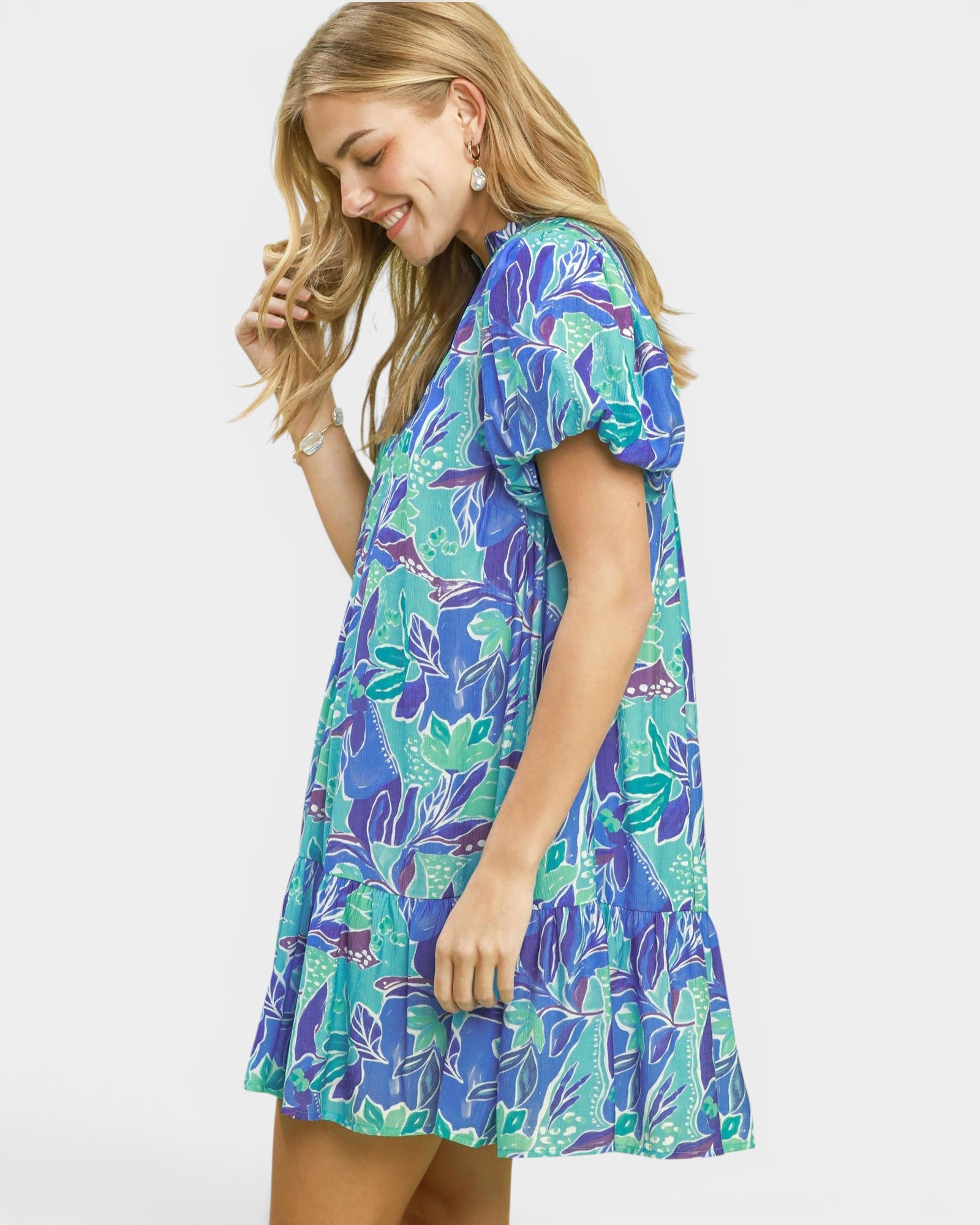 Woman wearing a colorful floral dress on a white background