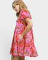 Woman wearing a colorful floral dress on a white background