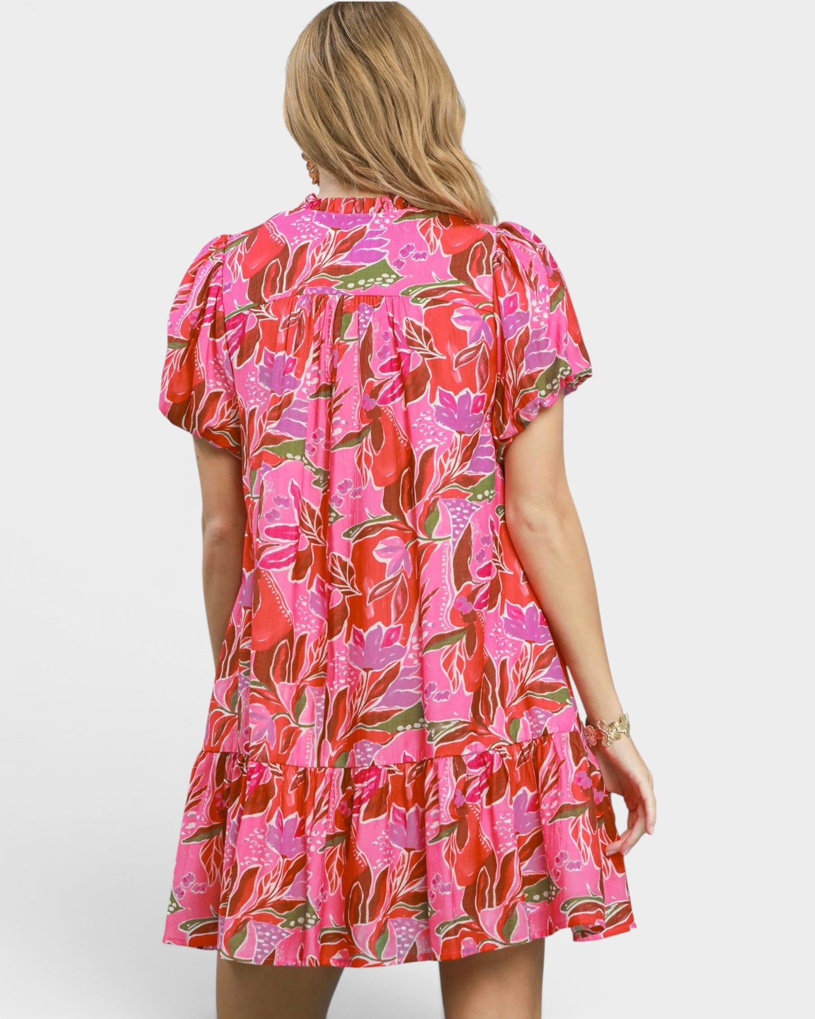 Woman wearing a pink floral dress on a white background