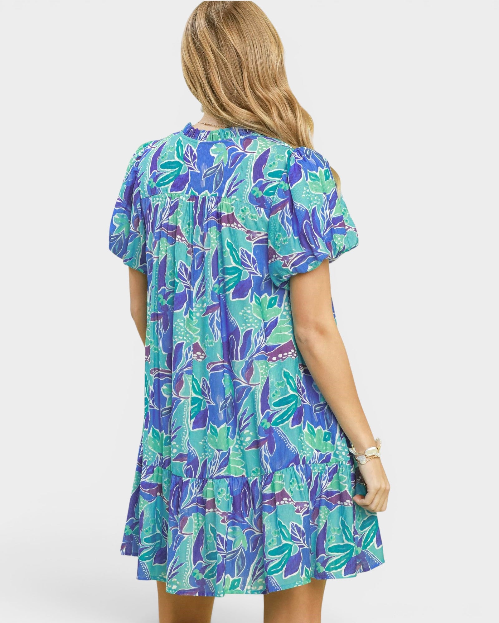 Woman wearing a colorful floral dress on a white background