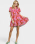 Woman wearing a pink floral dress on a white background