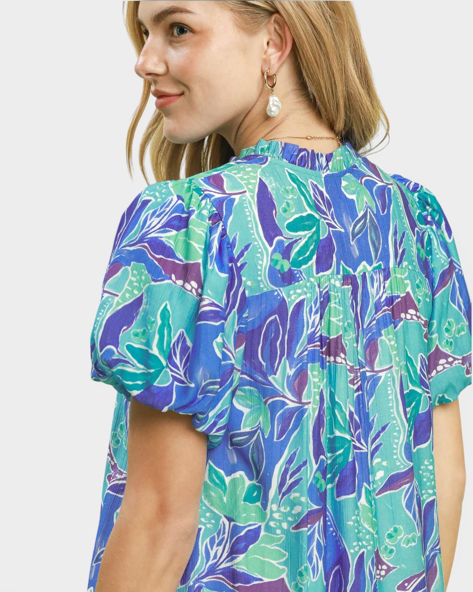 Woman wearing a colorful floral blouse with a white background