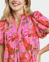 Woman wearing a pink floral dress with a white background