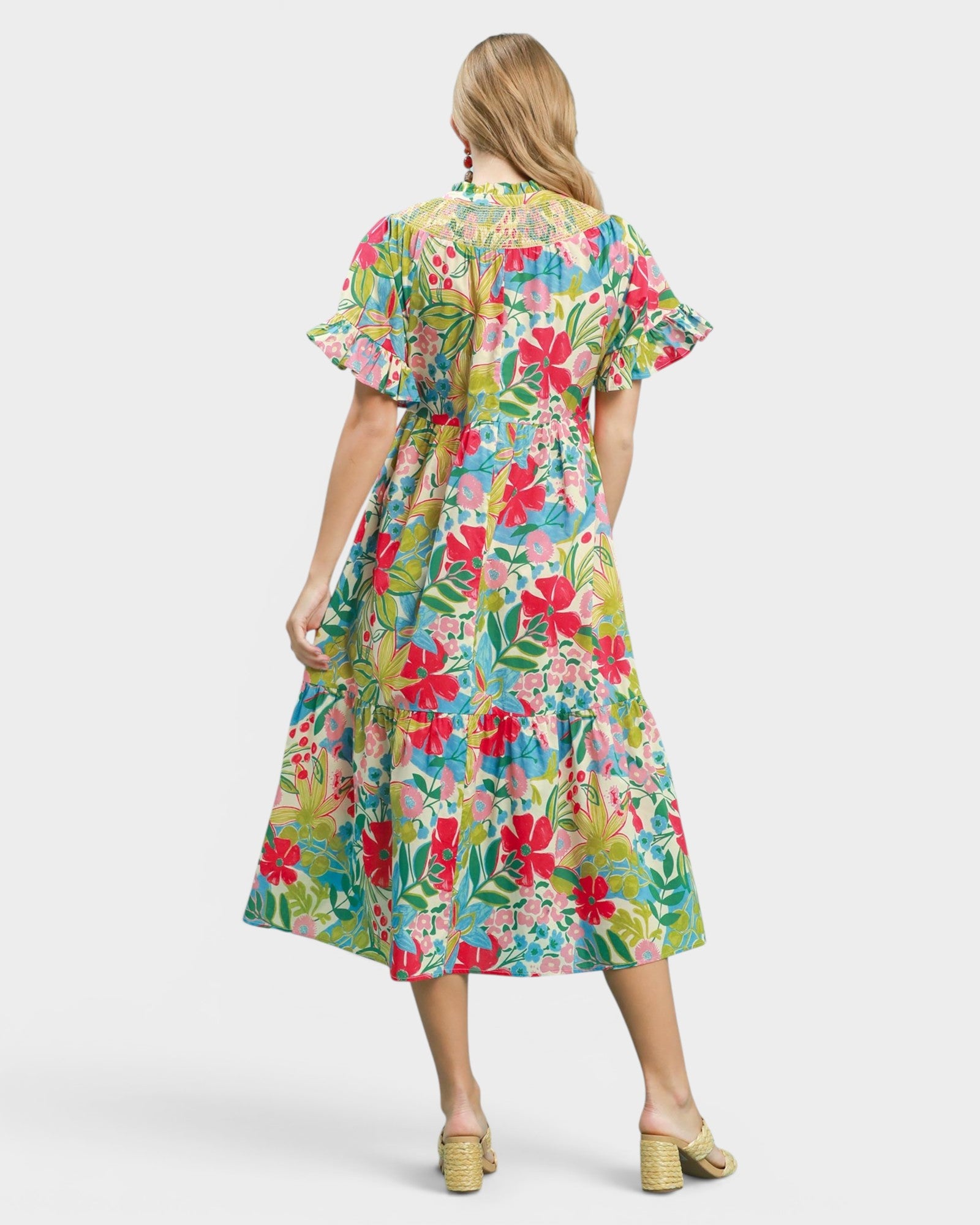 Woman wearing a colorful floral dress on a white background