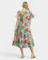 Woman wearing a colorful floral dress on a white background