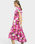 Woman wearing a pink floral dress on a white background
