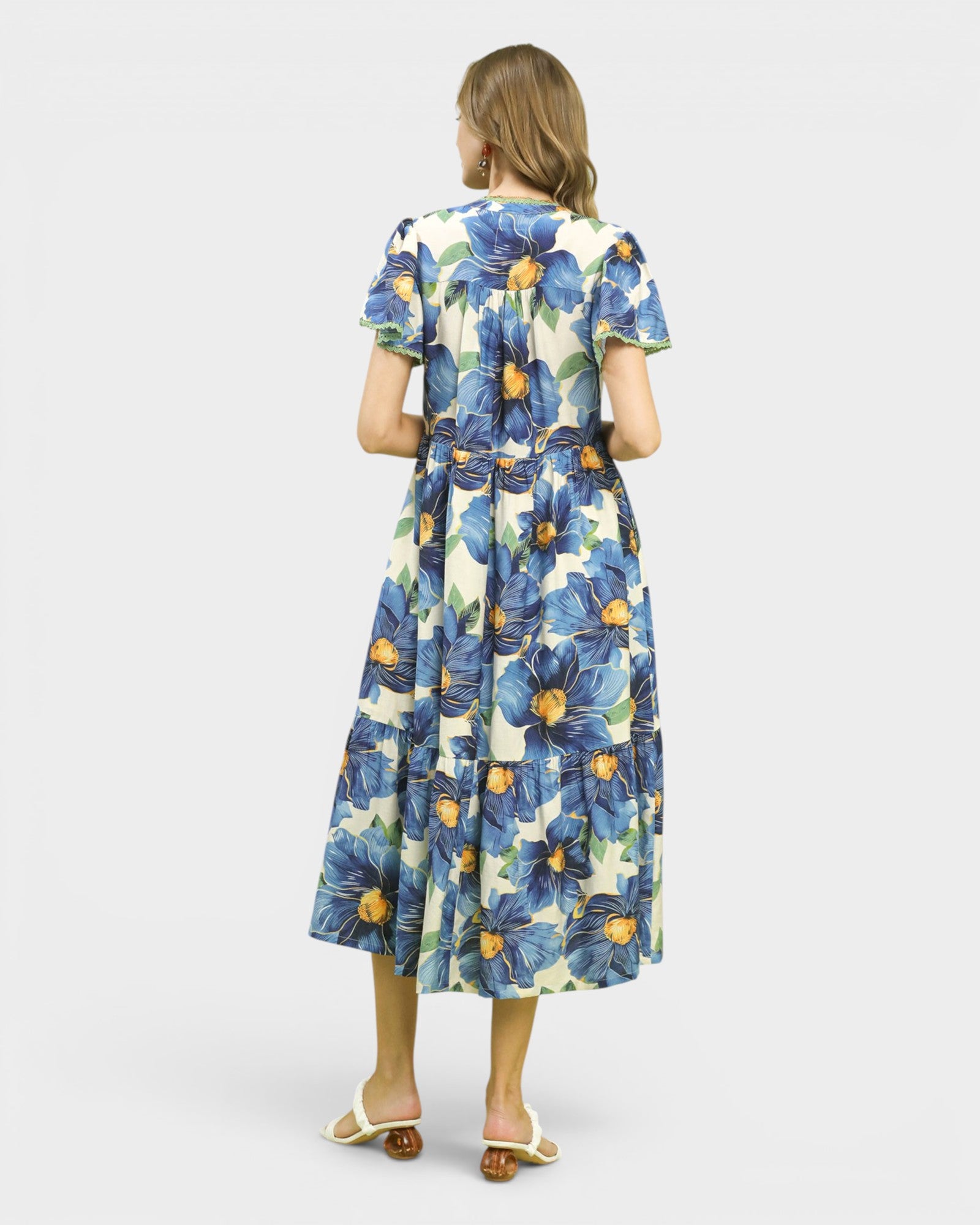 Woman wearing a floral dress with blue flowers on a white background
