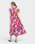 Woman wearing a pink floral dress on a white background