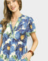 Woman wearing a blue floral dress against a plain background