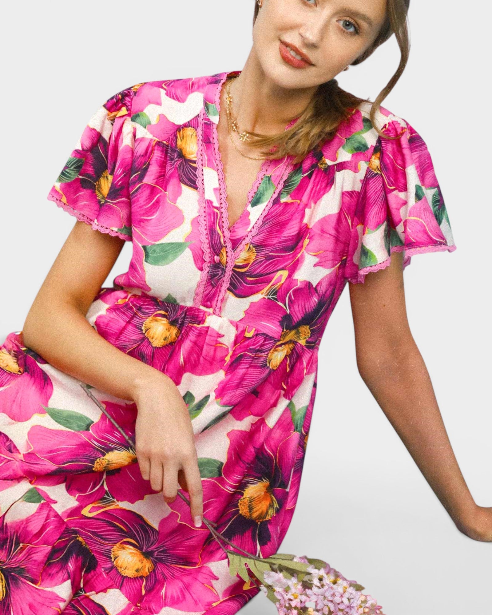 Woman wearing a vibrant floral dress on a white background